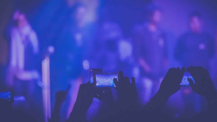 People in a concert taking videos.