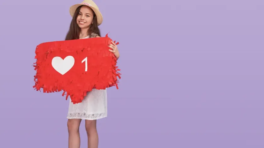 Young girl holding up a social media like button.